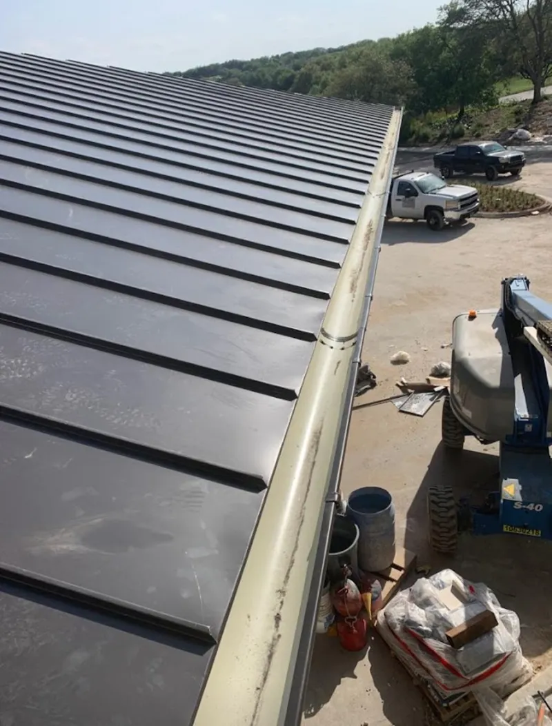 Standing seam panel and gutter detail on a metal roofing jobsite in Crestwood